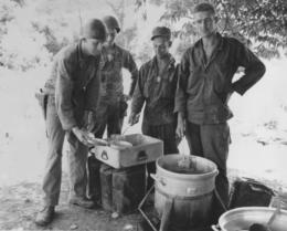 Cavalryment from the 1st Cavalry Division being served hot chow from an impromptu serving line in Korea, July 25, 1950