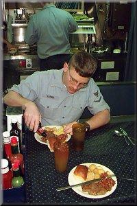 A USS Pittsburgh sailor sailors chows down with some maximum intensity