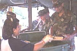 Tray in hand, 1st Lt. Steven Foster, 203rd Mobile Public Affairs Detachment, Wichita, Kan., enters the Mobile Kitchen Trailer at base camp Motagua, Puerto Barrios, Guatemala, while on humanitarian relief duty with New Horizons '99.  Serving Foster is Maria Garcia, a Guatemalan KP.