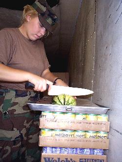  Private First Class Barbie Huscussun, of Dover, Ohio, a member 
of the 1485th Transportation Company, Canton, Ohio, prepares watermelon for the evening meal.